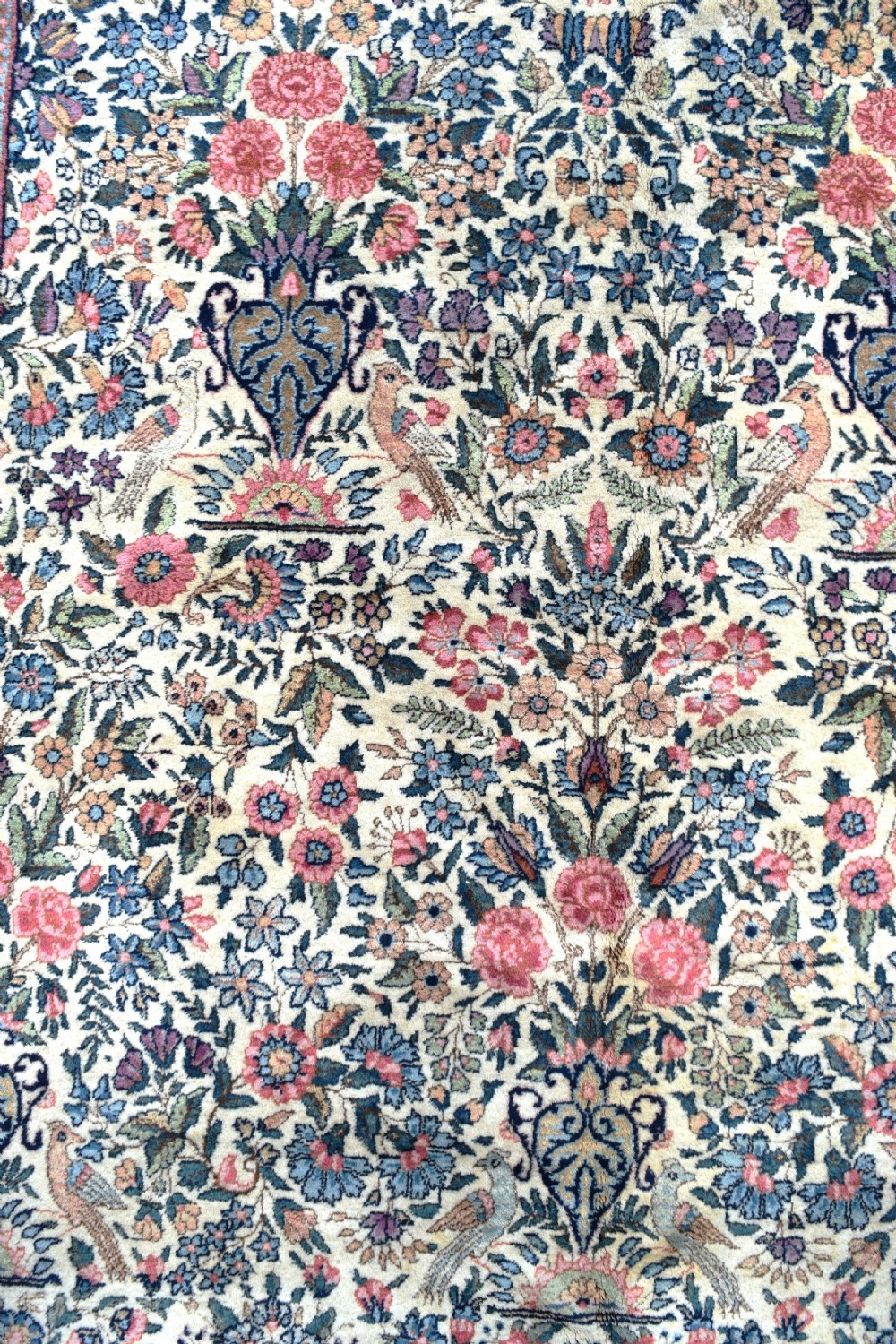 A large hand-knotted Persian Kirman room-size carpet featuring an intricate floral and vase pattern in cream, rose pink, and slate blue. View VIII