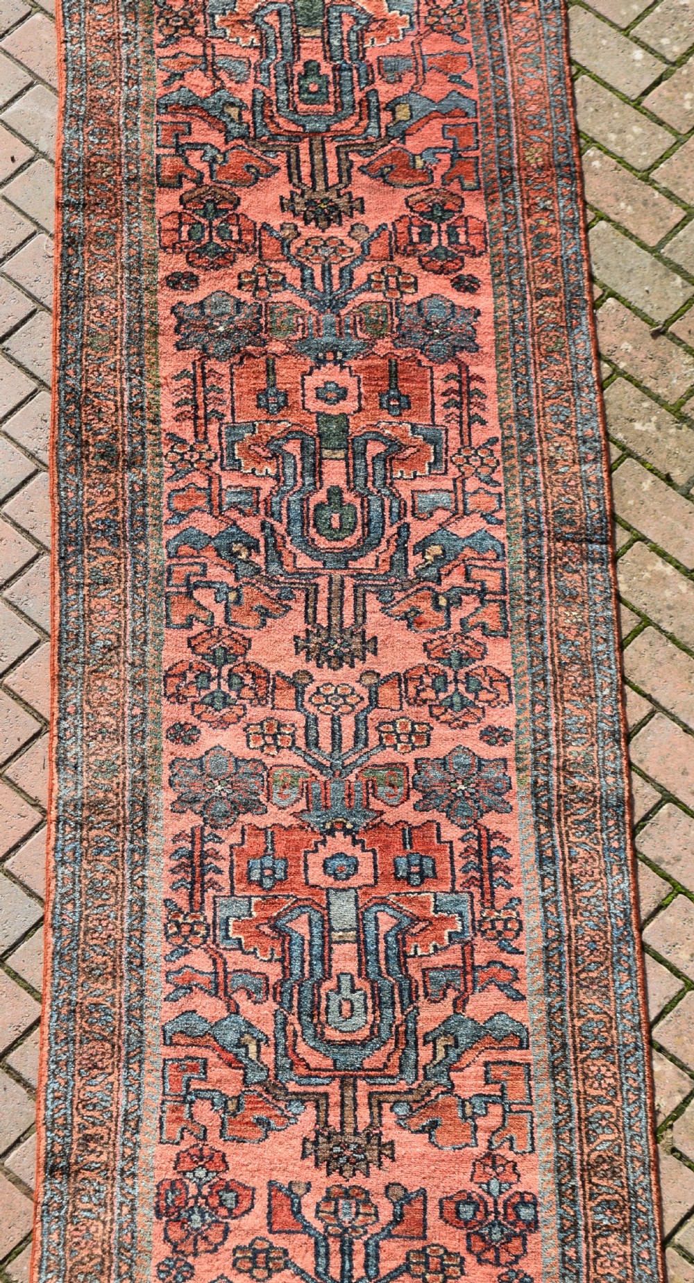A pair of exceptionally long, narrow antique Persian Hamadan runners featuring intricate geometric and stylized floral motifs in blue and ivory on a terracotta wool ground. View VI