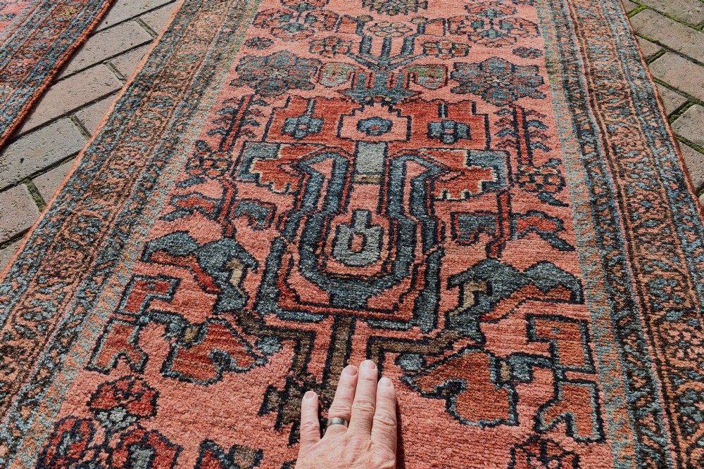 A pair of exceptionally long, narrow antique Persian Hamadan runners featuring intricate geometric and stylized floral motifs in blue and ivory on a terracotta wool ground. View VIII