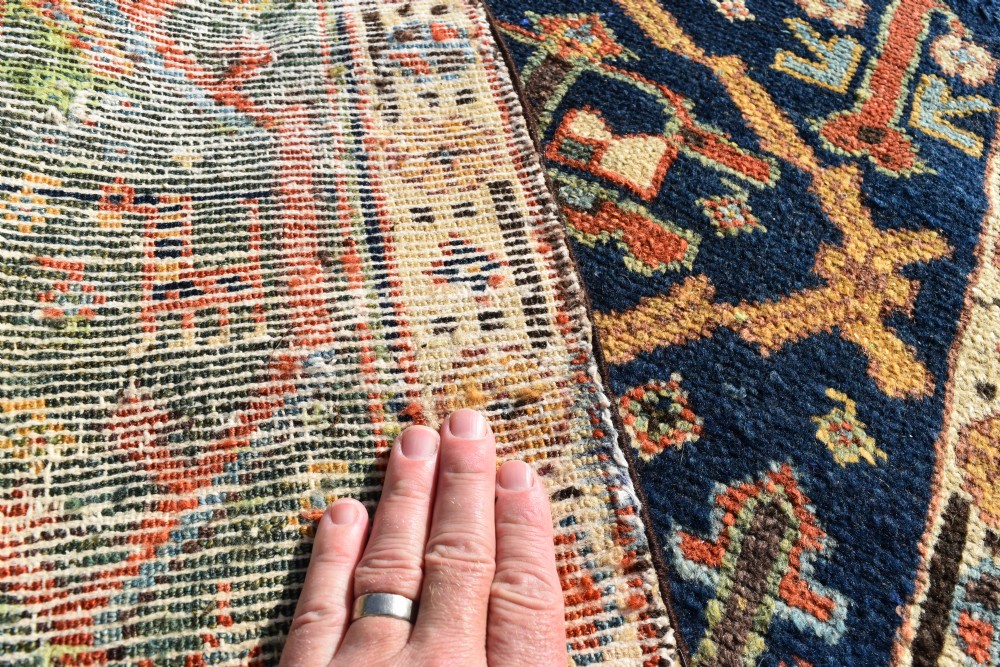 An extra long antique hand-knotted wool runner rug with a dark blue central panel of geometric diamond medallions and terracotta patterned borders. View IX