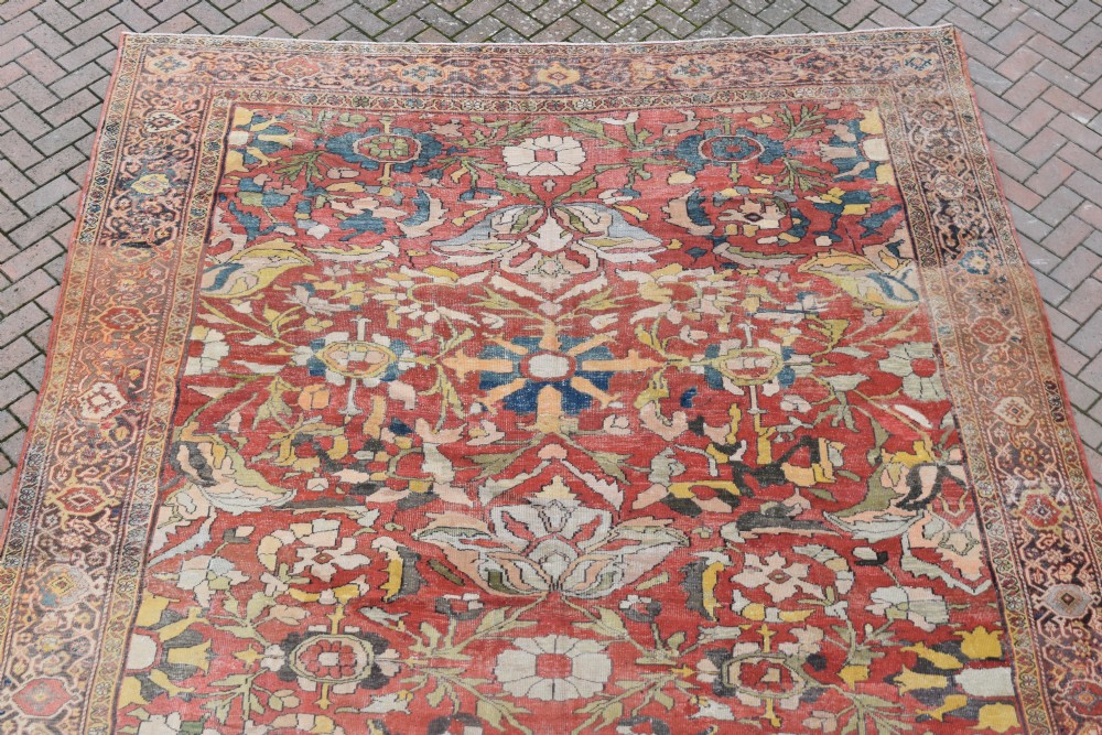 A large antique Persian Sultanabad hand-knotted wool carpet with large botanical palmettes on a terracotta field enclosed by multi-band borders. View IV