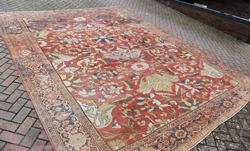 A large antique Persian Sultanabad hand-knotted wool carpet with large botanical palmettes on a terracotta field enclosed by multi-band borders. View VI