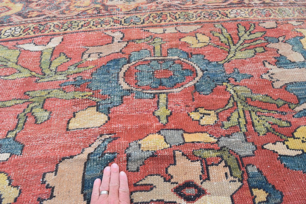 A large antique Persian Sultanabad hand-knotted wool carpet with large botanical palmettes on a terracotta field enclosed by multi-band borders. View IX