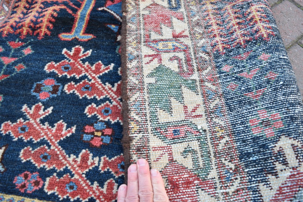 A long antique Persian Bakhtiari runner rug featuring stylised tree motifs in red, blue, and pink on a dark navy ground with a geometric border. View VII