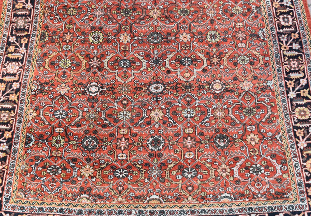 A large rectangular antique Mahal carpet featuring an all-over intricate floral lattice pattern in terracotta red and cream framed by a wide navy border. View II