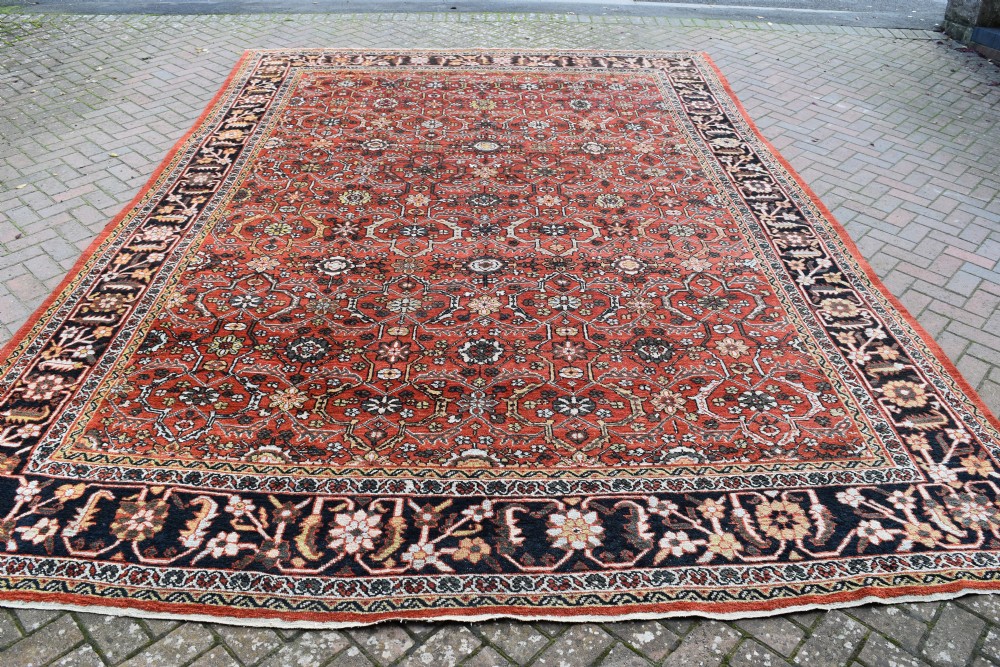 A large rectangular antique Mahal carpet featuring an all-over intricate floral lattice pattern in terracotta red and cream framed by a wide navy border. View III