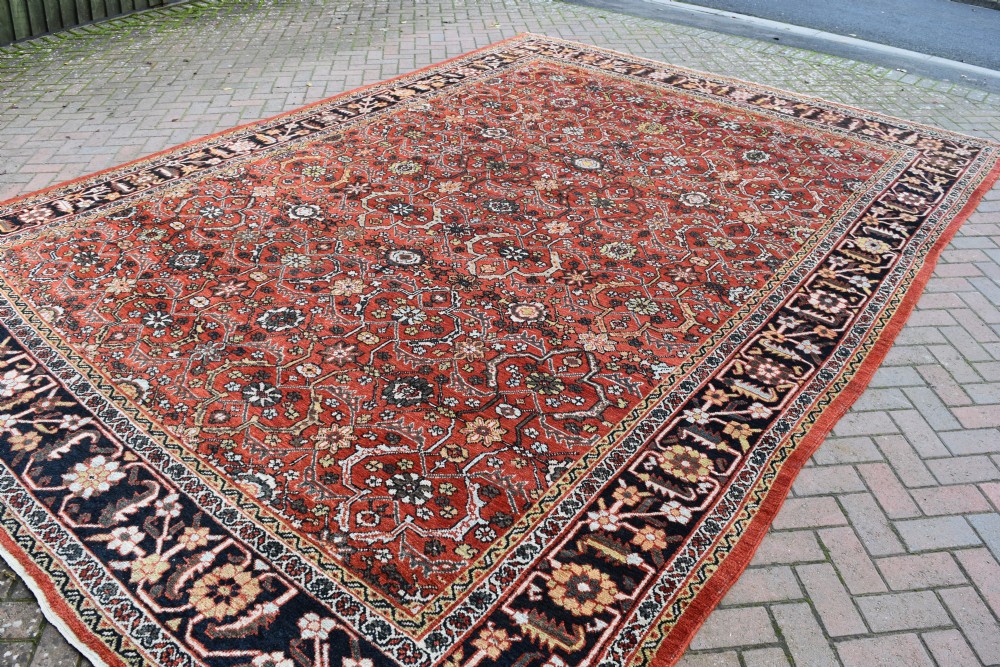 A large rectangular antique Mahal carpet featuring an all-over intricate floral lattice pattern in terracotta red and cream framed by a wide navy border. View V