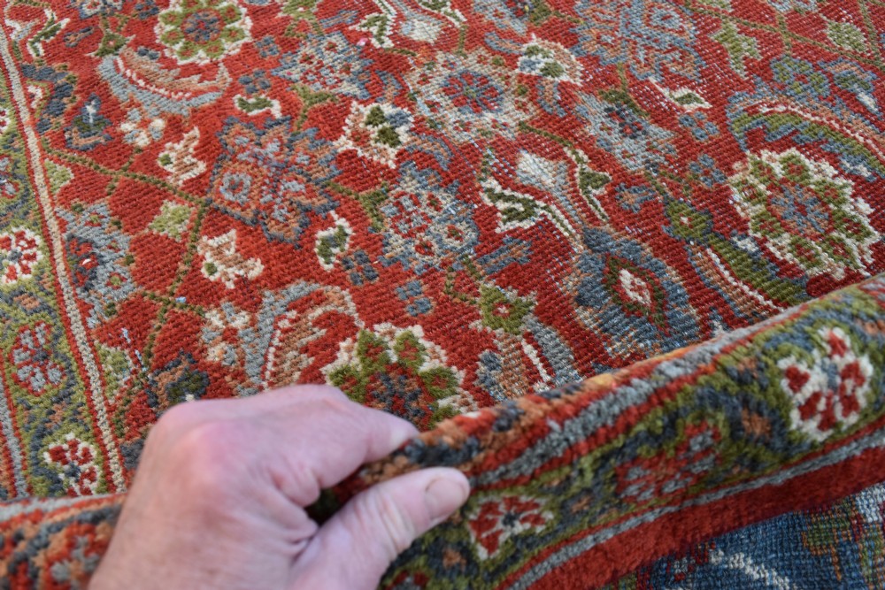 A large rectangular hand-knotted Sultanabad rug featuring an all-over floral lattice pattern on a terracotta red field with a slate blue palmette border. View VII