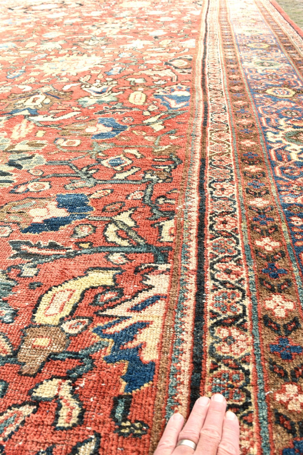 An oversized hand-knotted antique Persian Mahal carpet featuring an intricate terracotta red field and complex dark navy blue floral borders. View VIII