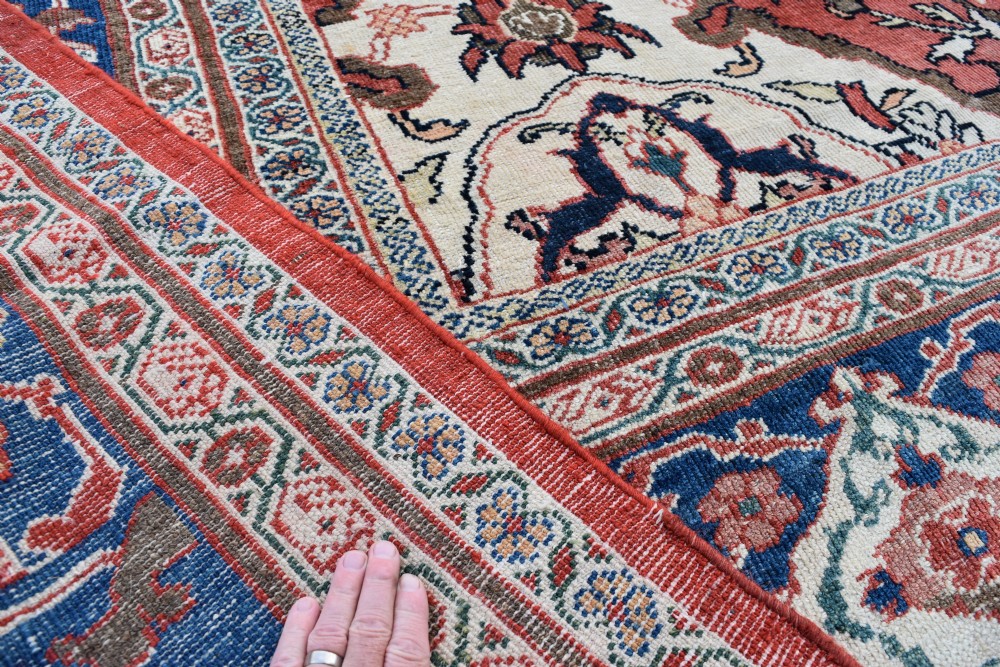Large antique Ziegler Mahal wool carpet featuring a terracotta field with a central navy blue medallion and ornate floral borders. View II