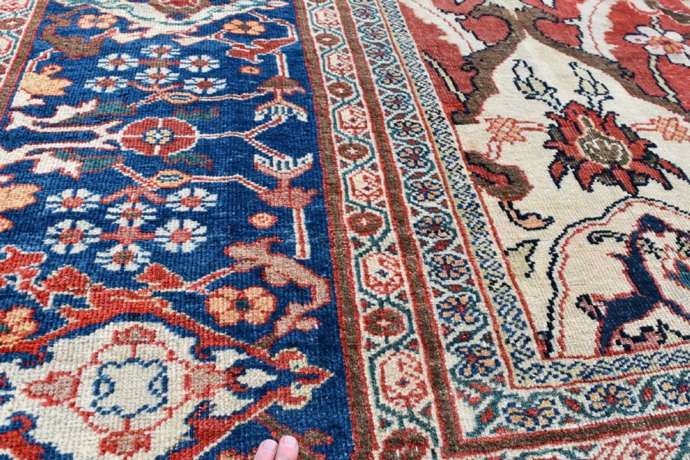 Large antique Ziegler Mahal wool carpet featuring a terracotta field with a central navy blue medallion and ornate floral borders. View XI