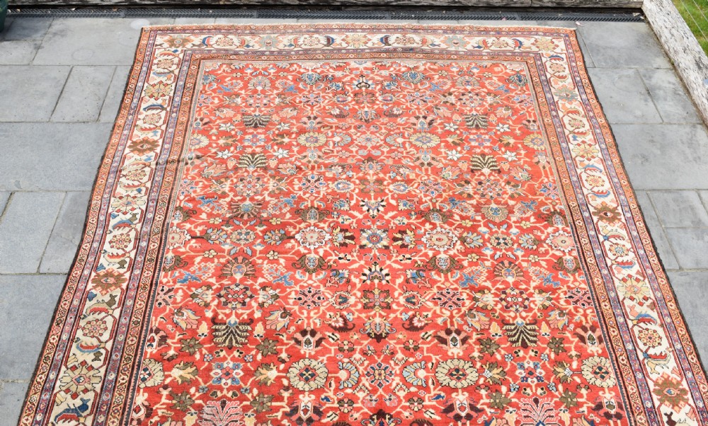 A large hand-knotted antique Persian Mahal carpet featuring a rust-red field filled with an intricate all-over floral pattern surrounded by a contrasting cream main border. View III
