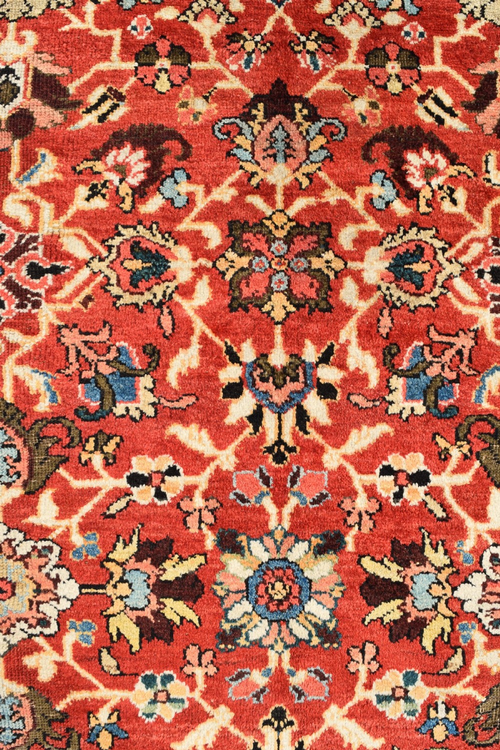 A large hand-knotted antique Persian Mahal carpet featuring a rust-red field filled with an intricate all-over floral pattern surrounded by a contrasting cream main border. View IV