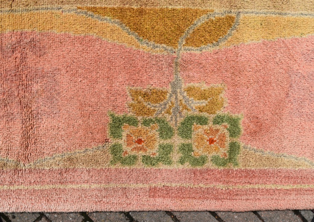 A large Arts and Crafts hand-knotted wool carpet in pink featuring mustard yellow and green stylised floral borders. View VIII
