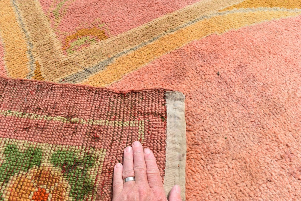 A large Arts and Crafts hand-knotted wool carpet in pink featuring mustard yellow and green stylised floral borders. View X