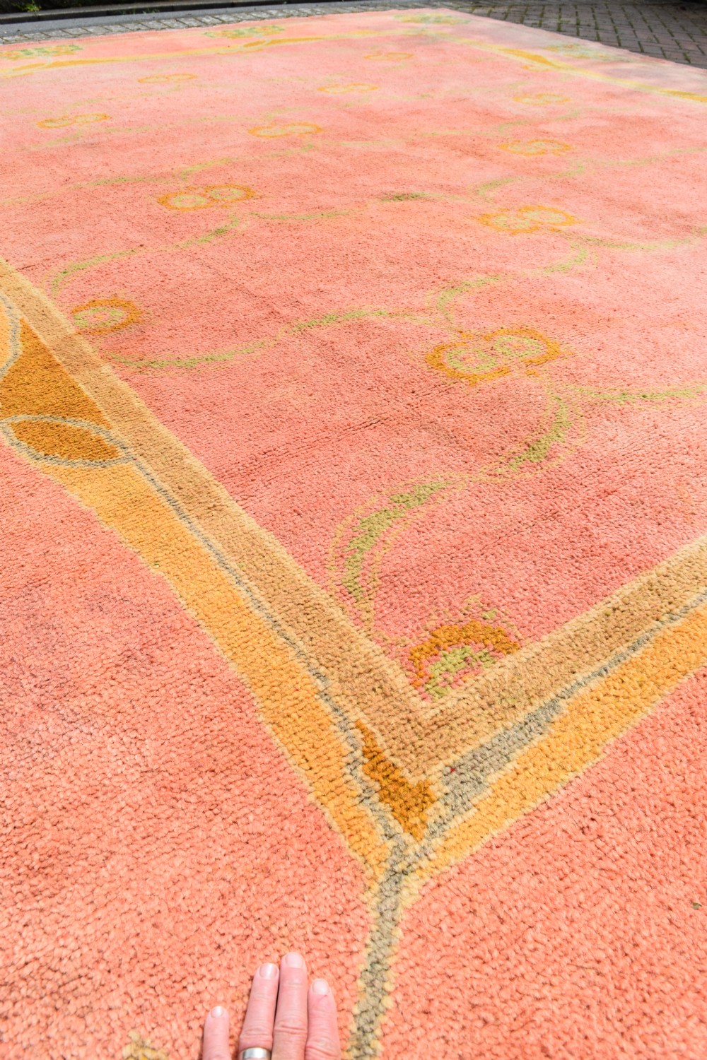 A large Arts and Crafts hand-knotted wool carpet in pink featuring mustard yellow and green stylised floral borders. View XI