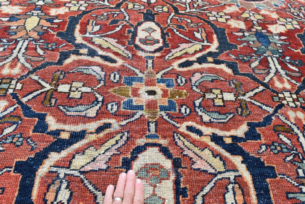 A large rectangular hand-knotted Persian Mahal carpet featuring a terracotta red ground with an all-over navy blue and beige floral palmette pattern framed by intricate borders. View IV