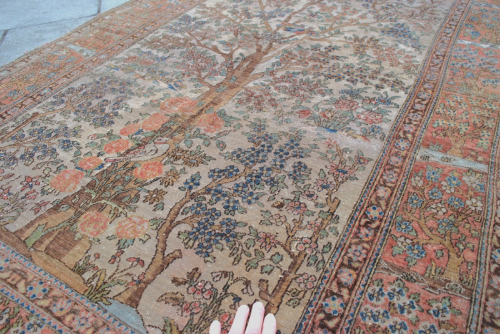 An antique Persian Isfahan wool rug featuring a central Tree of Life pictorial motif with birds framed by a terracotta floral border. View III