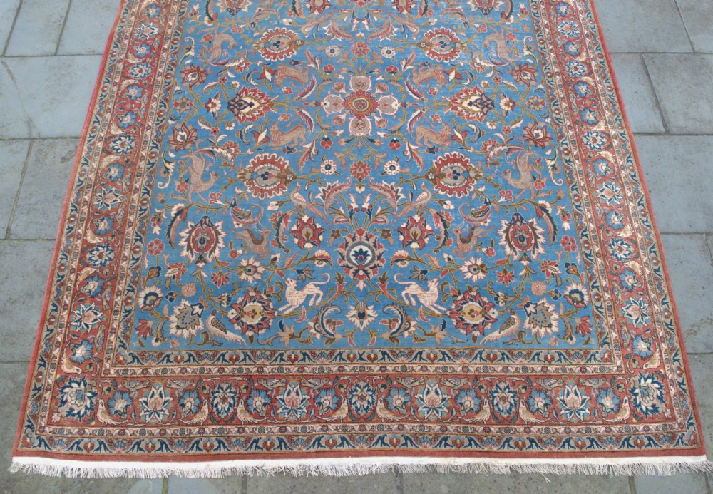 A large hand-knotted wool Veramin carpet featuring a central sky-blue field detailed with animals, birds, and floral vine scrolls inside a red multi-bordered frame. View II