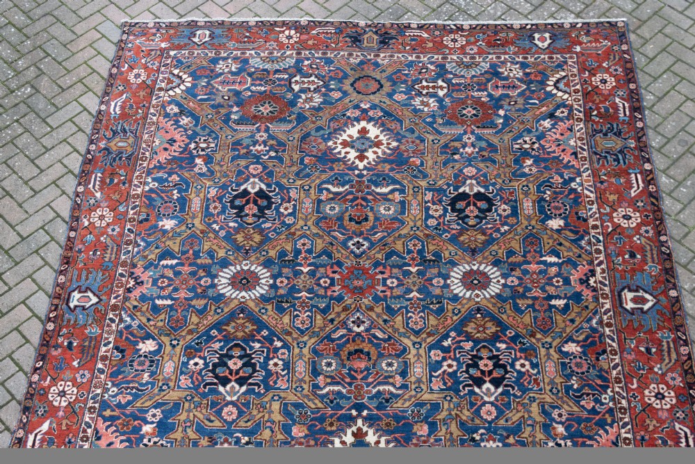 A large hand-knotted antique Heriz wool carpet featuring geometric floral motifs in deep blue, terracotta red, and ivory tones. View III