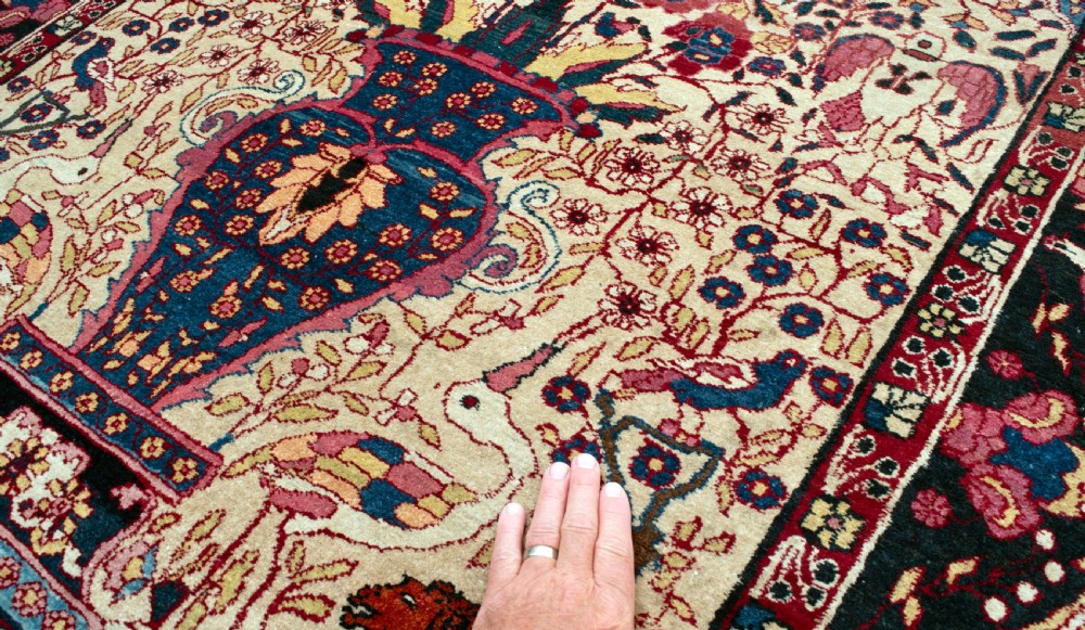 A pair of antique hand-knotted prayer rugs featuring ivory fields decorated with central vase and bird motifs under arched blue mihrabs. View II