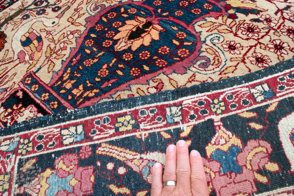 A pair of antique hand-knotted prayer rugs featuring ivory fields decorated with central vase and bird motifs under arched blue mihrabs. View III