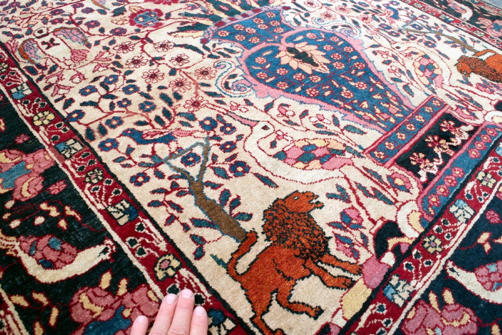 A pair of antique hand-knotted prayer rugs featuring ivory fields decorated with central vase and bird motifs under arched blue mihrabs. View IV