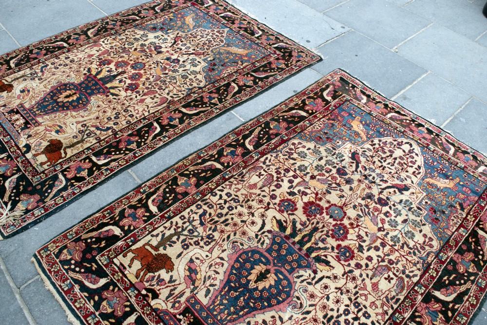 A pair of antique hand-knotted prayer rugs featuring ivory fields decorated with central vase and bird motifs under arched blue mihrabs. View V