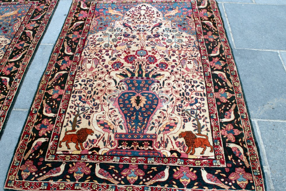 A pair of antique hand-knotted prayer rugs featuring ivory fields decorated with central vase and bird motifs under arched blue mihrabs. View VI