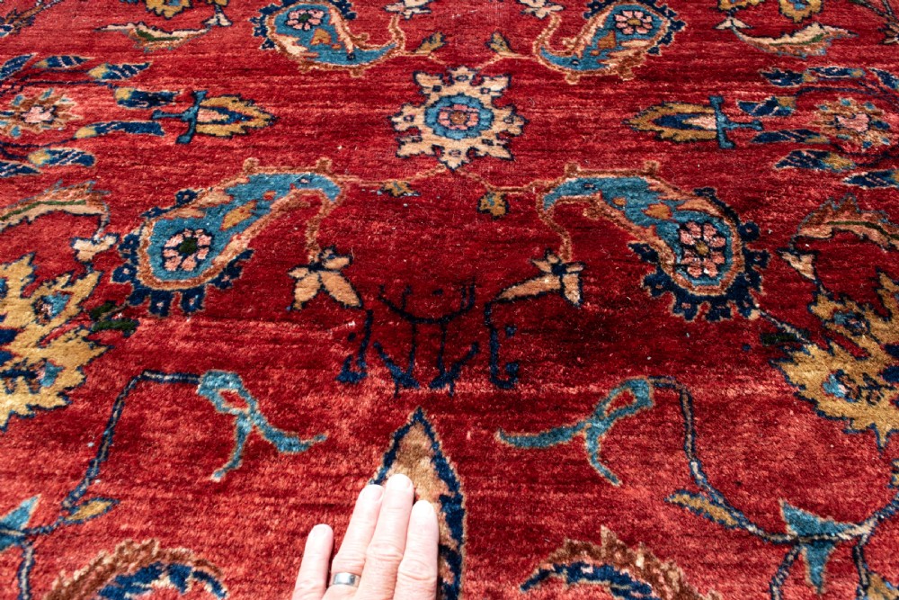 A large hand-knotted Persian Kashan carpet featuring a detailed red field covered in floral motifs framed by a multi-tiered navy blue border. View II
