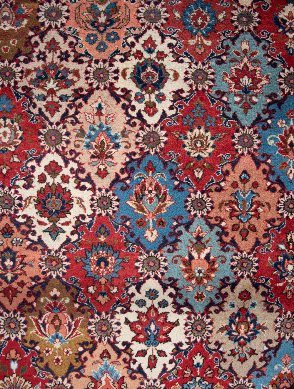A large hand-knotted antique Persian Tabriz carpet displaying an intricate diamond lattice floral pattern in red, blue, and cream tones. View III