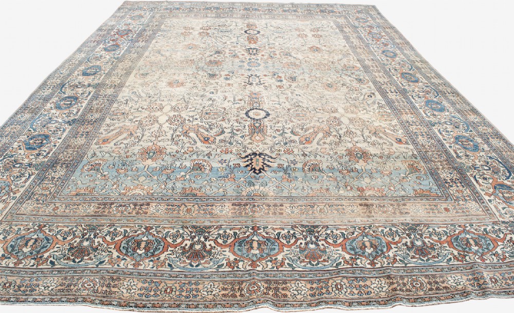 An oversize hand-knotted Khorasan carpet featuring a cream field with floral palmettes and a multi-tiered blue and terracotta border. View III
