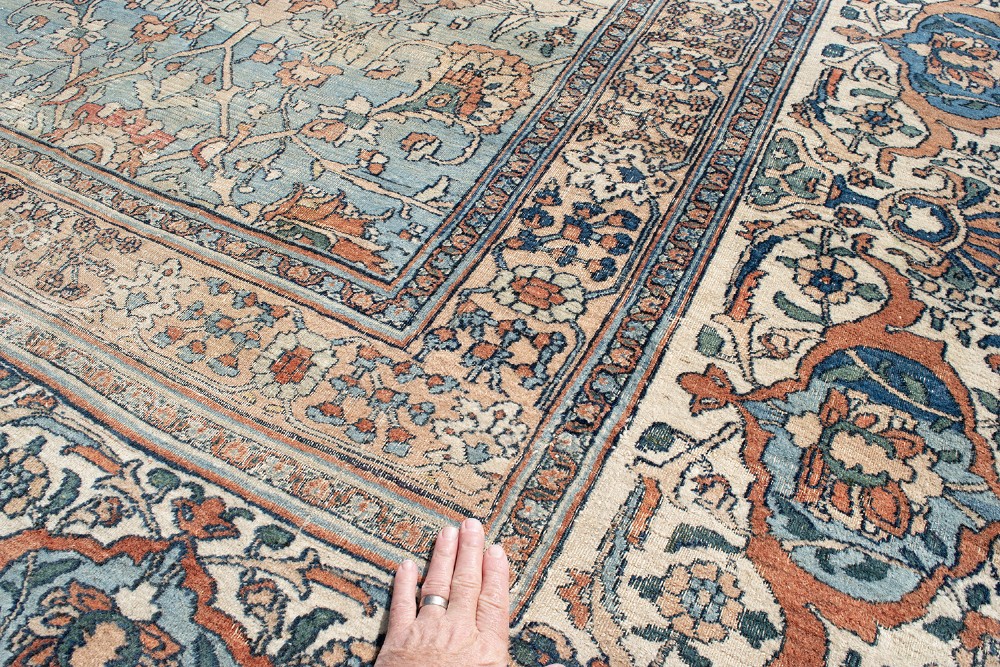 An oversize hand-knotted Khorasan carpet featuring a cream field with floral palmettes and a multi-tiered blue and terracotta border. View IV