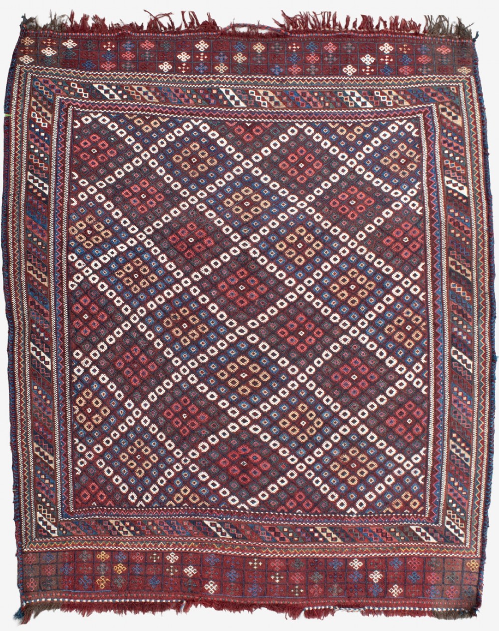 An antique Persian Afshar flatwoven Sofreh rug with a geometric diamond lattice pattern in crimson red, navy blue, and cream.