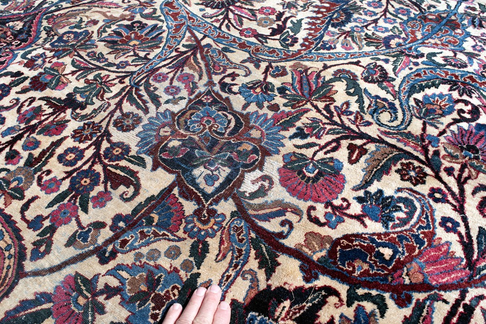A large Kirman wool carpet featuring intricate floral scrollwork, paisley boteh motifs, and a central medallion in cream, magenta, and navy blue tones. View VIII