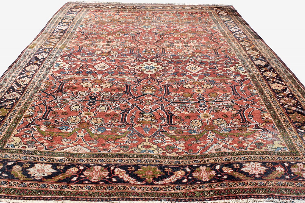 A large hand-knotted antique Persian Mahal carpet featuring a terracotta field filled with an intricate floral lattice pattern framed by a navy blue floral border. View V