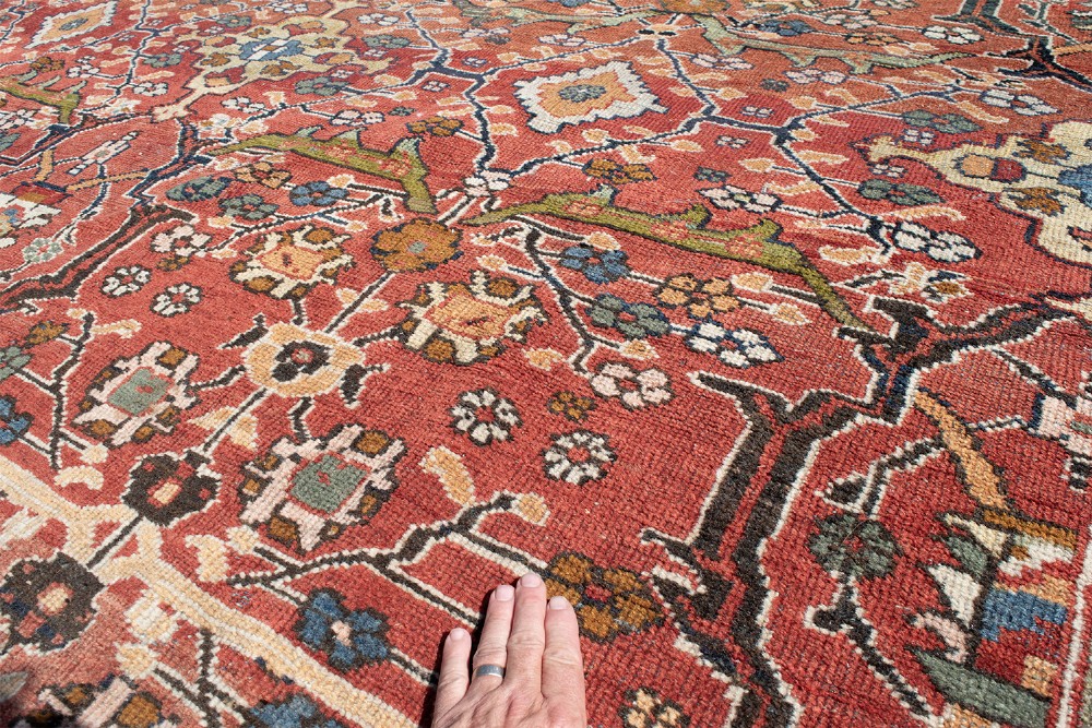 A large hand-knotted antique Persian Mahal carpet featuring a terracotta field filled with an intricate floral lattice pattern framed by a navy blue floral border. View VIII