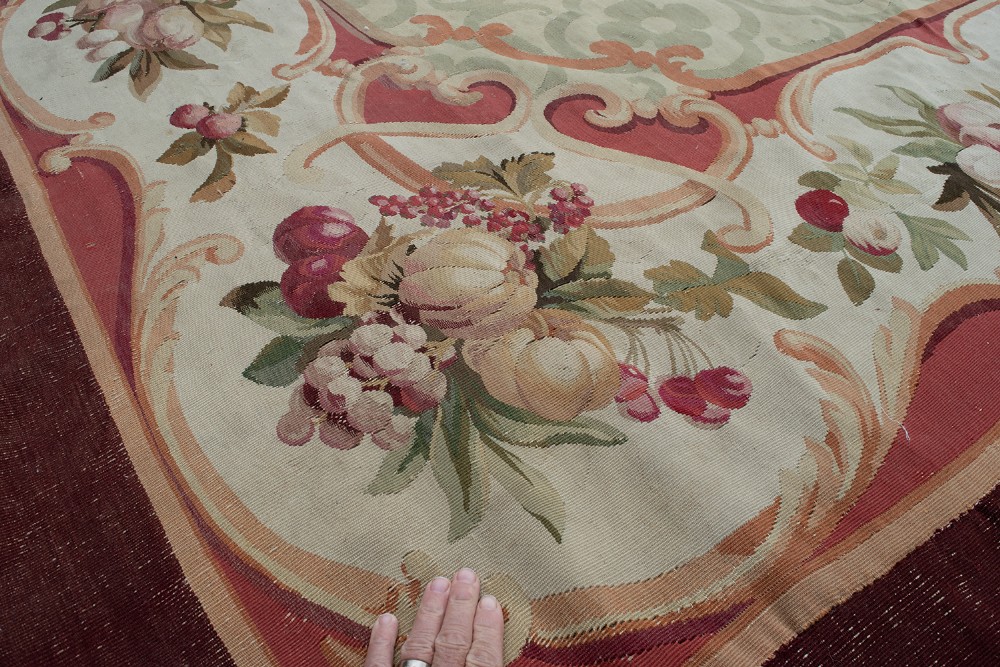 An antique French Aubusson flat-weave carpet featuring a central sage green geometric field framed by a rich floral cartouche border and a solid burgundy outer rim. View IV