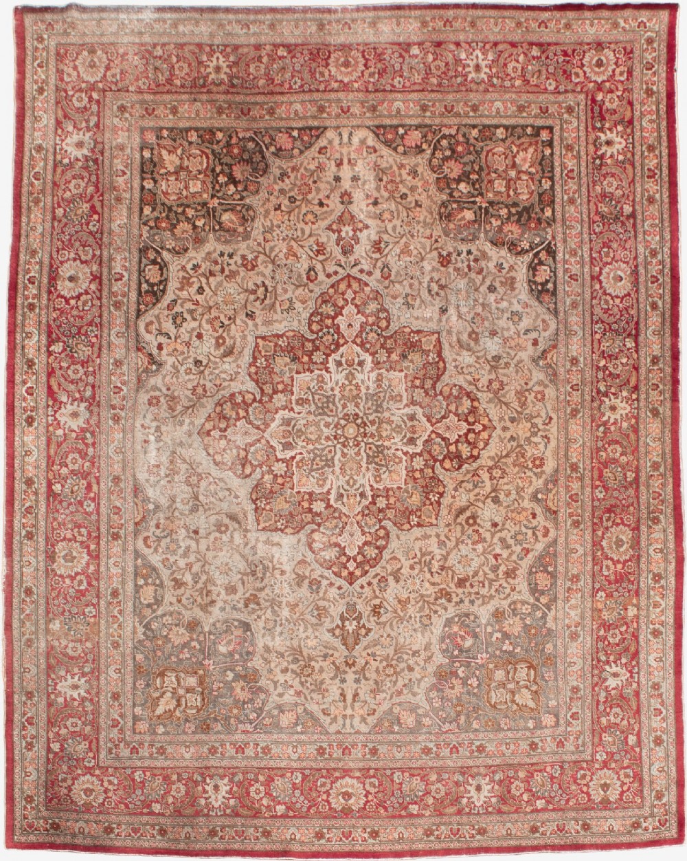 A large Persian Tabriz carpet featuring a central floral medallion on a cream field framed by deep red borders.