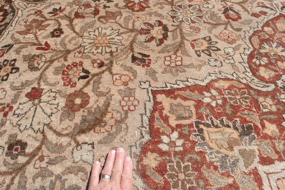 A large Persian Tabriz carpet featuring a central floral medallion on a cream field framed by deep red borders. View VIII