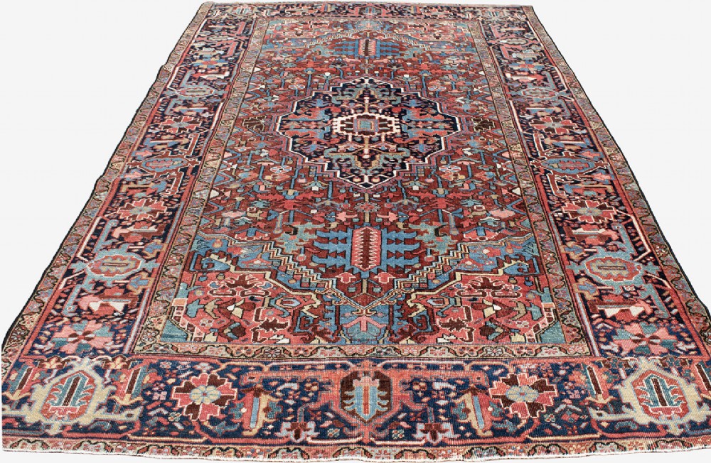 A hand-knotted Heriz wool rug featuring a central navy and ivory geometric medallion on a terracotta red field surrounded by intricate floral borders. View III