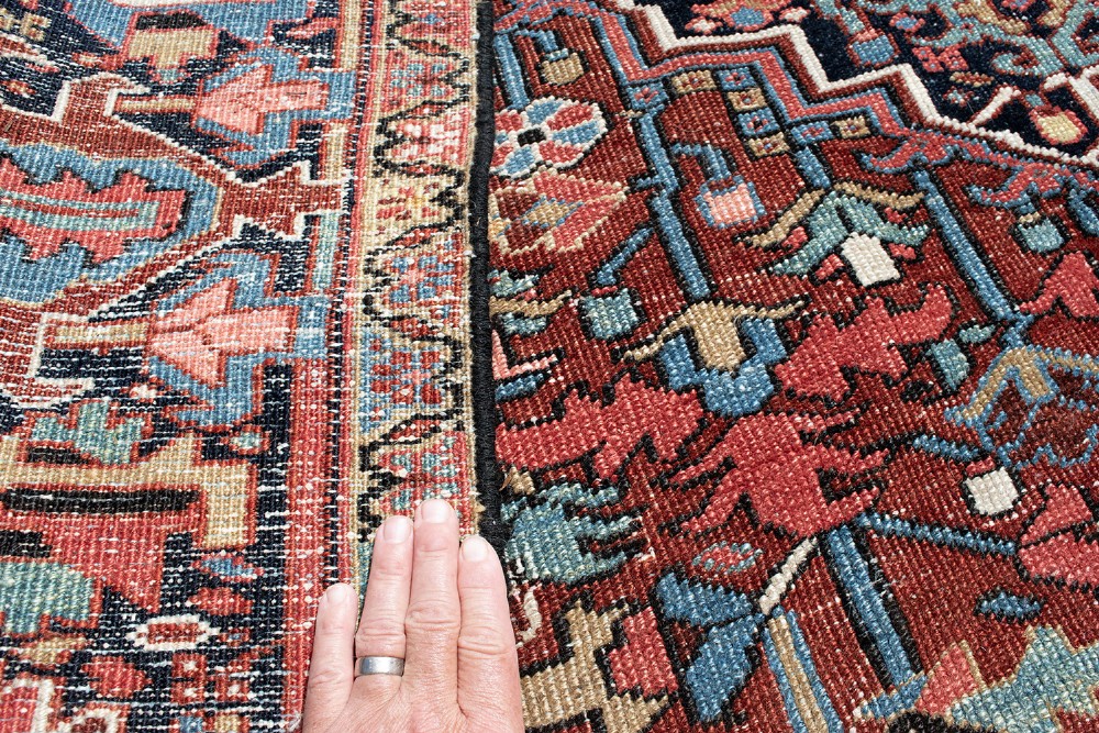 A hand-knotted Heriz wool rug featuring a central navy and ivory geometric medallion on a terracotta red field surrounded by intricate floral borders. View VIII
