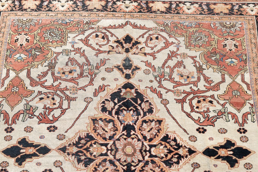 A large hand-knotted antique Mahal Persian carpet featuring a central dark blue floral medallion on an ivory field framed by terracotta spandrels and a multi-tiered border. View IV