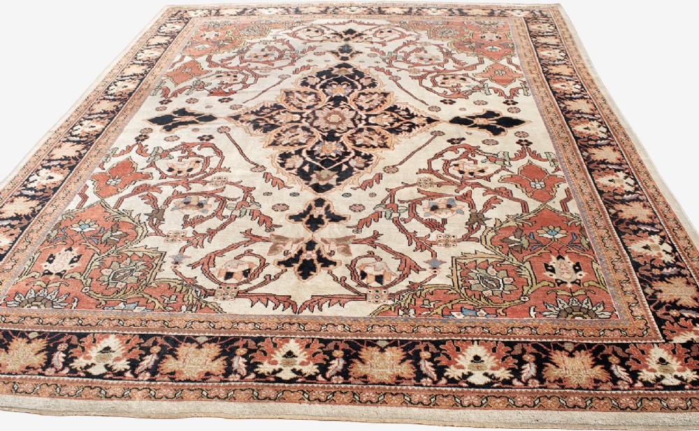 A large hand-knotted antique Mahal Persian carpet featuring a central dark blue floral medallion on an ivory field framed by terracotta spandrels and a multi-tiered border. View V