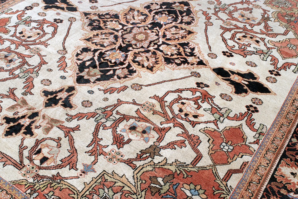 A large hand-knotted antique Mahal Persian carpet featuring a central dark blue floral medallion on an ivory field framed by terracotta spandrels and a multi-tiered border. View VI