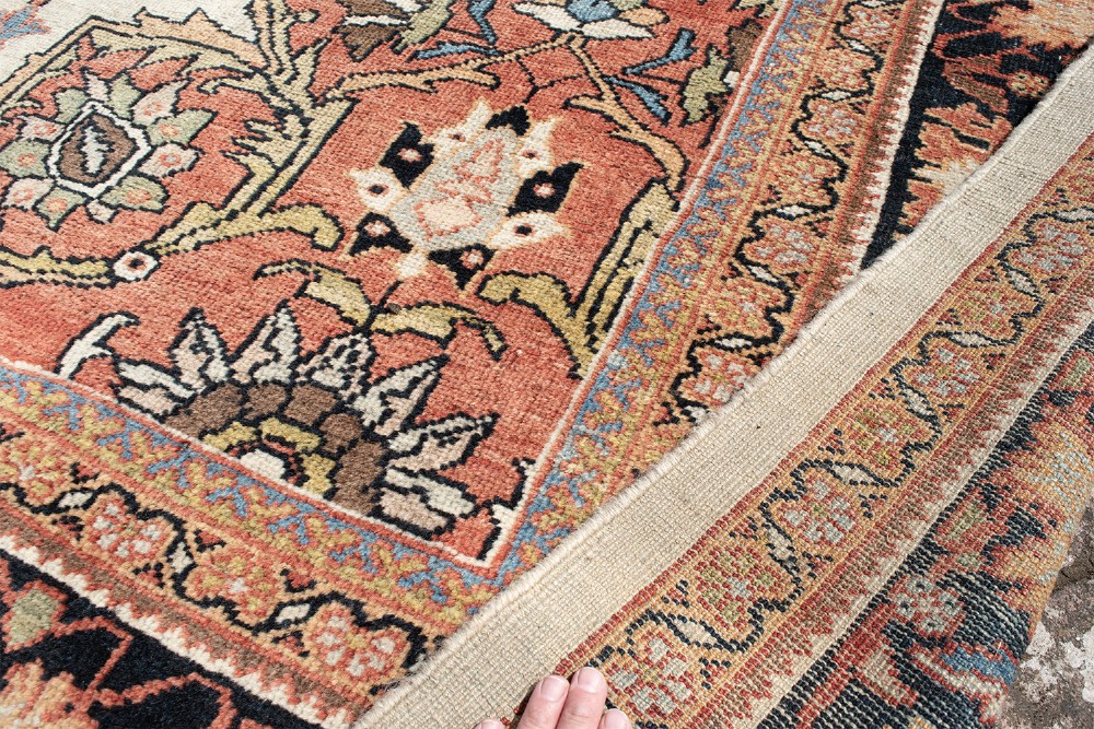 A large hand-knotted antique Mahal Persian carpet featuring a central dark blue floral medallion on an ivory field framed by terracotta spandrels and a multi-tiered border. View X