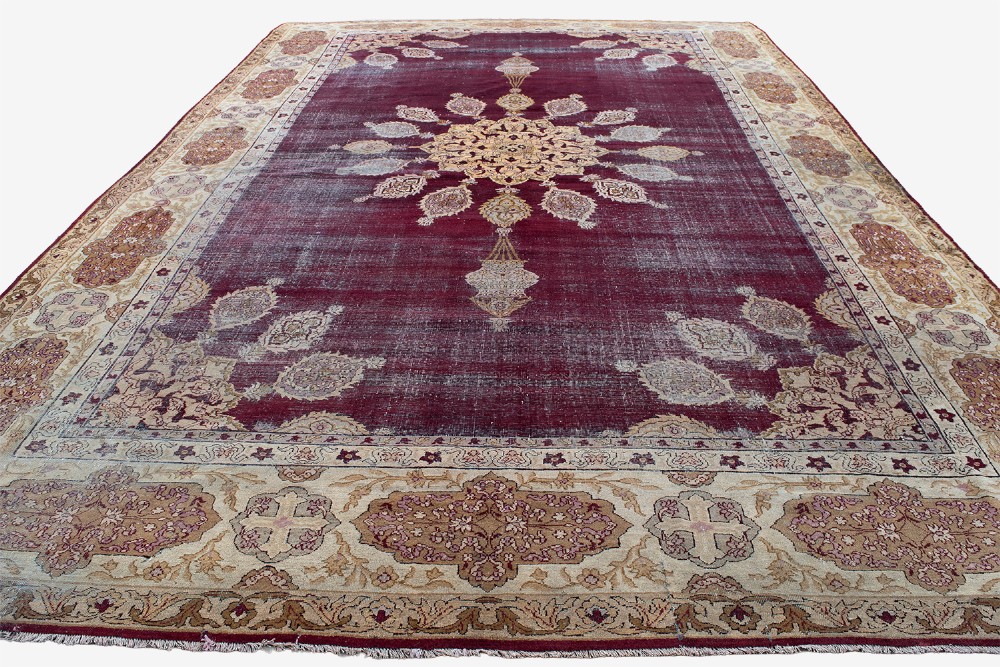 A large hand-knotted wool carpet featuring a central starburst medallion surrounded by floral motifs on a deep magenta field with a broad cream patterned border. View VII