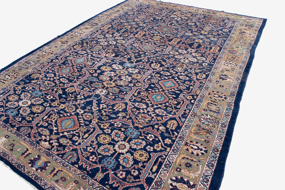 A large hand-knotted antique Persian Mahal carpet featuring intricate floral palmette patterns in navy, terracotta, and soft green across a dark blue field. View V