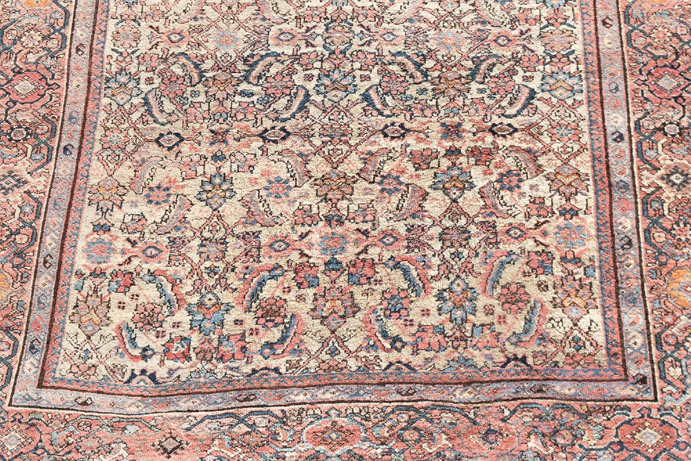 An antique Persian Ferahan wool carpet featuring a dense floral pattern on a cream field surrounded by a terracotta multi-banded border. View III