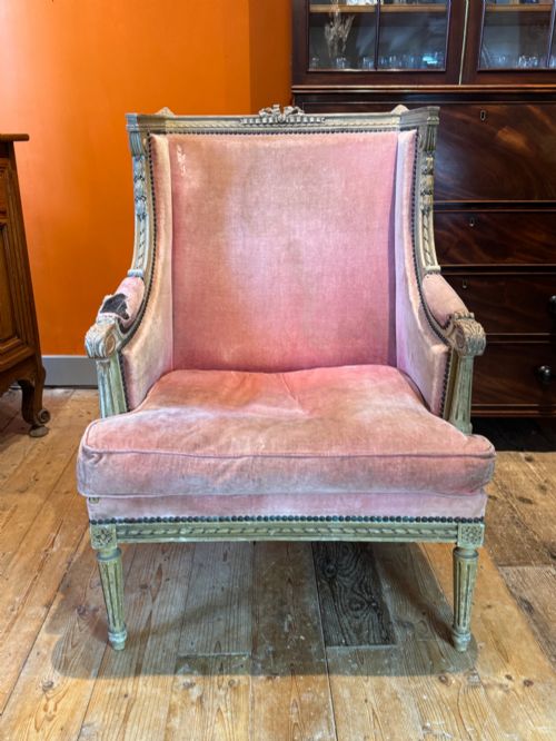 fig 1. An antique Louis XVI French bergere armchair with a grey painted carved wood frame and dusty pink velvet upholstery.